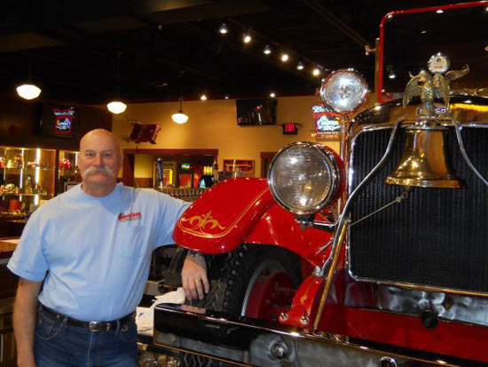 Captain Bill with Company 7 BBQ's Fire Engine Behind the Company 7 Bar